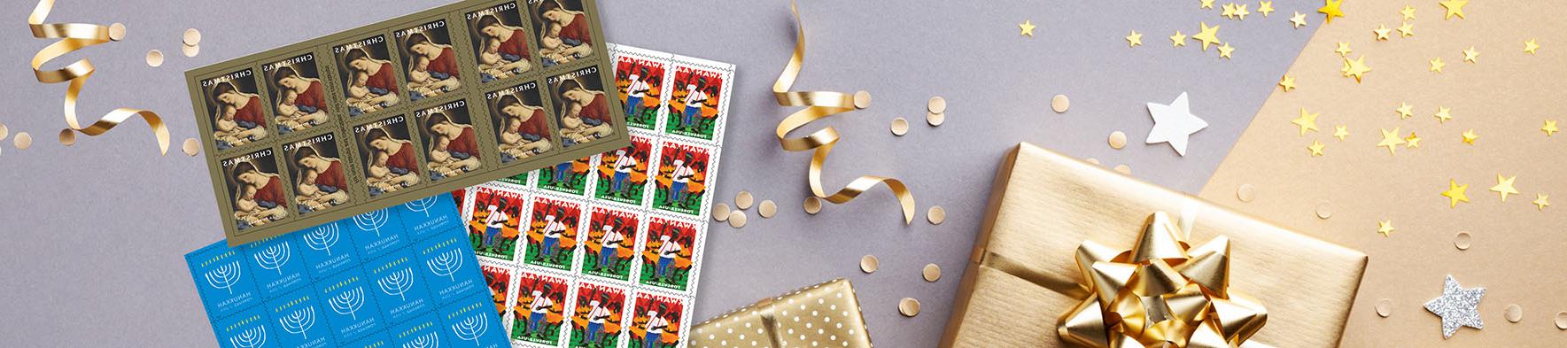 Holiday stamps on a table with a packaged gift, and holiday wrapping supplies.